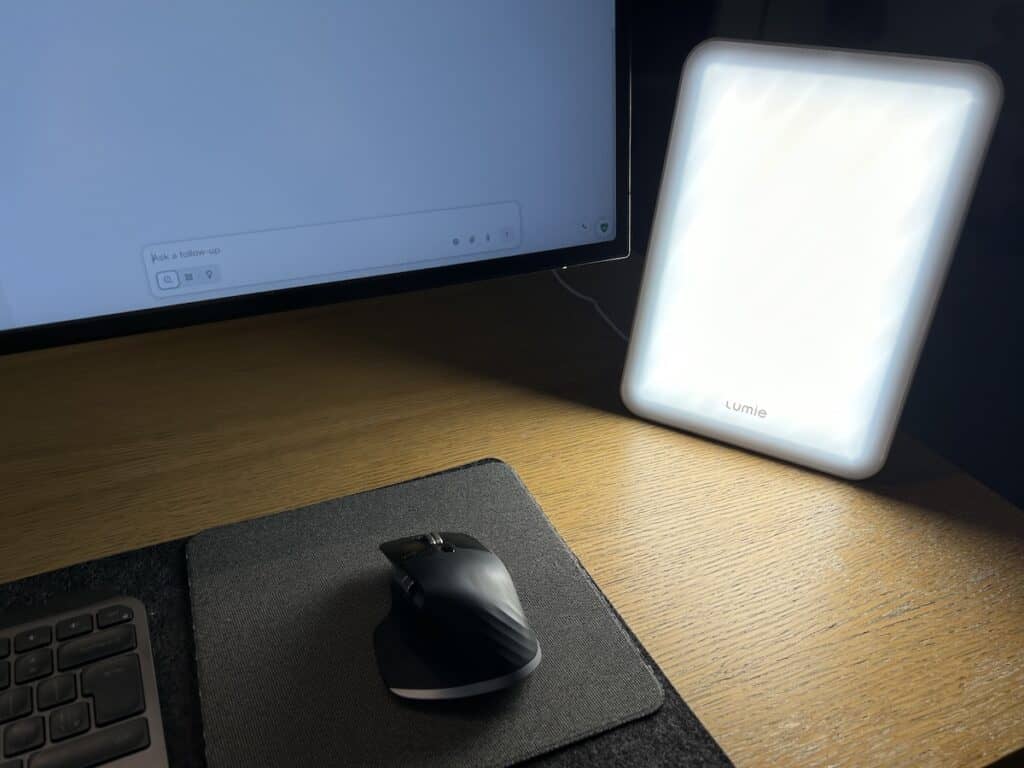 Bright LED light panel on wooden desk with computer, gaming mouse, and keyboard for comfortable workspace.